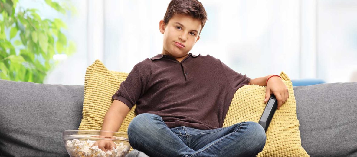 Bored kid on couch watching TV