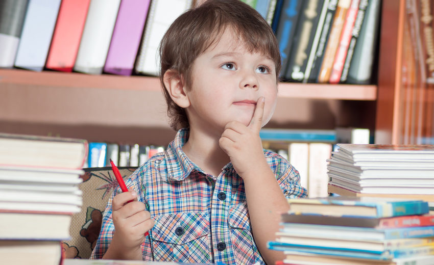 Preschooler sitting at a table with books