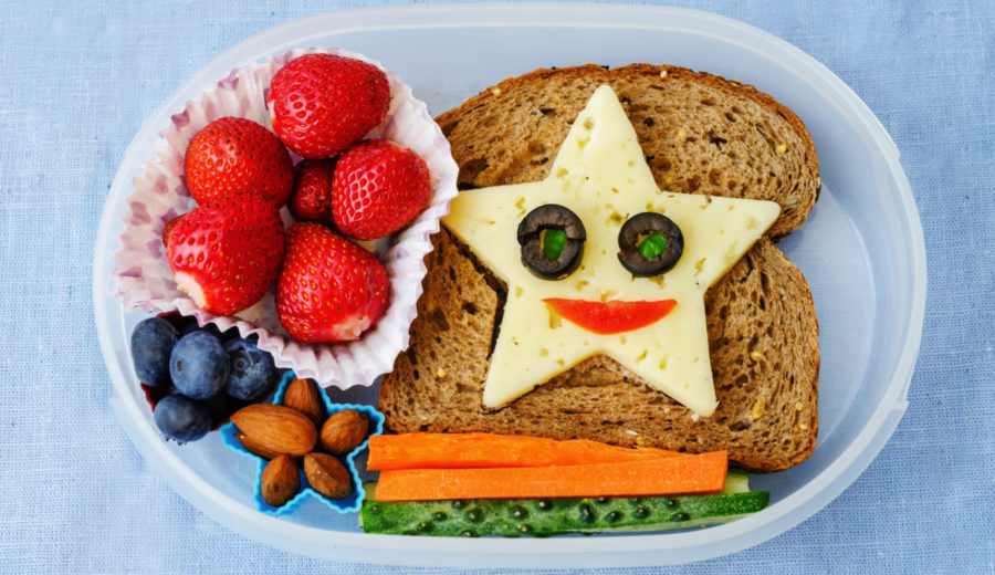 School lunch box for preschooler or toddler kids with healthy food in the form of funny faces